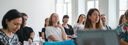 Gruppe Menschen sitzt bei einem Vortrag